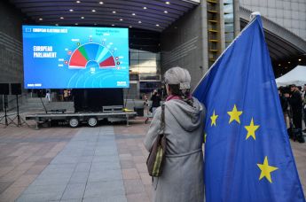 Женщина с флагом ЕС у штаб-квартиры Европпарламента в Брюсселе