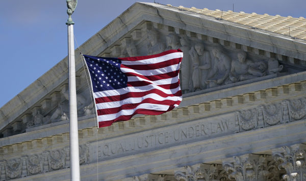 Американский флаг на фоне здания Верховного суда США в Вашингтоне