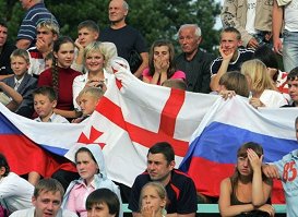 Люди с флагами России и Грузии.