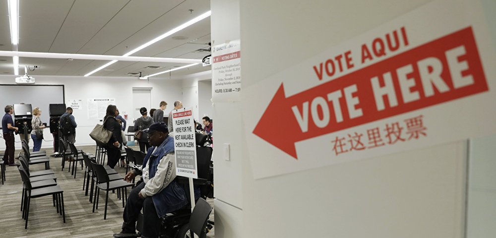 Вывеска "Голосовать здесь" на двери во время голосования в публичной библиотеке города Вашингтона, 2 ноября 2018 года