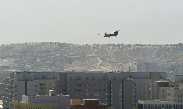 Американский вертолет CH-47 Chinook пролетает над крышей посольства США в Кабуле, 15 августа 2021