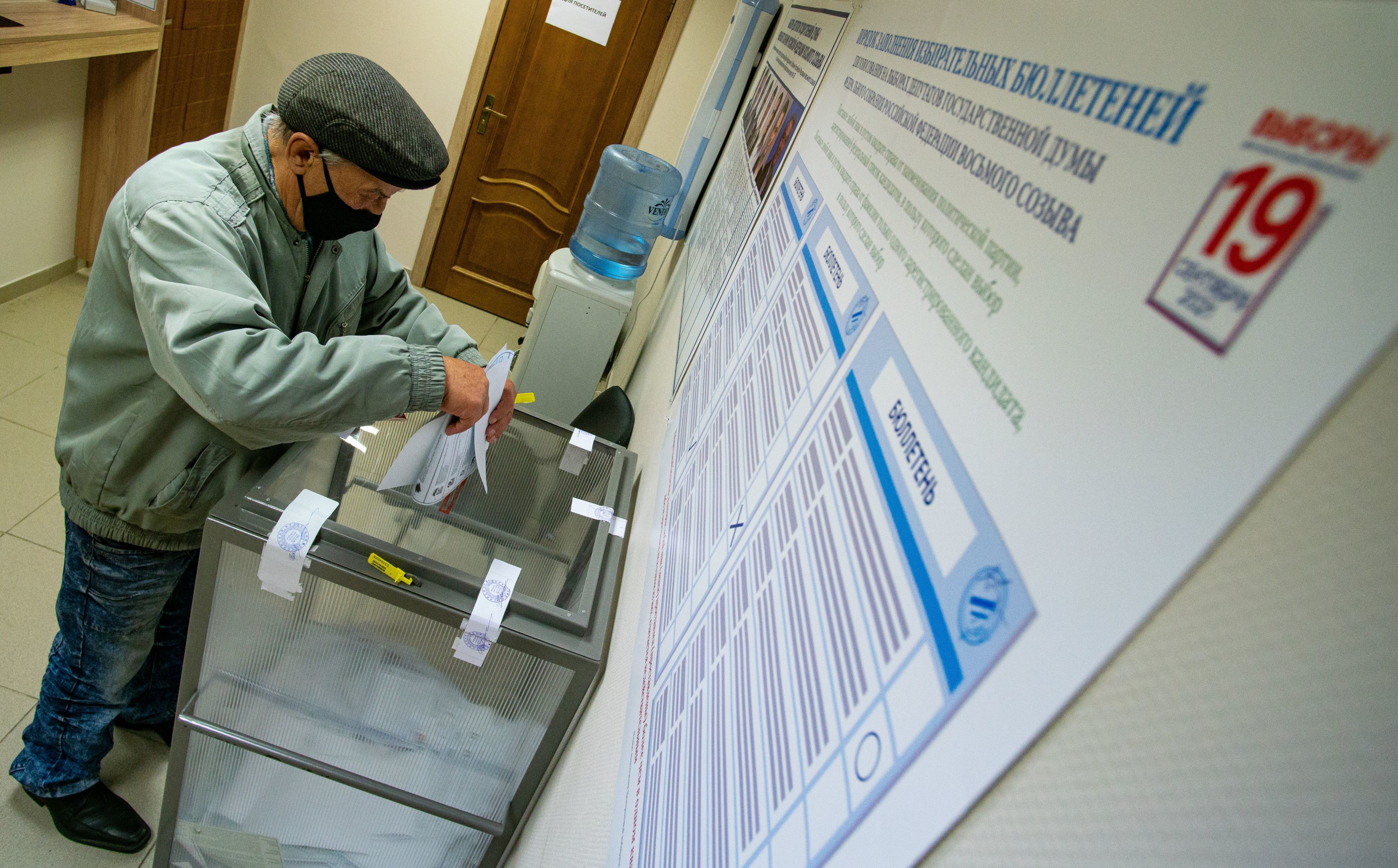 Мужчина голосует на выборах в Госдуму на избирательном участке в посольстве России в Латвии