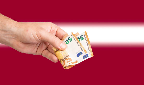 Купюра евро на фоне Латвийского флага
