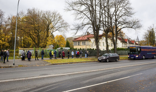 Люди стоят в очереди, чтобы вакцинироваться в автобусе для вакцинации Covid-19, в Риге, Латвия