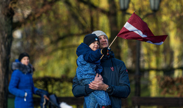 Мальчик держит в руках флаг Латвии