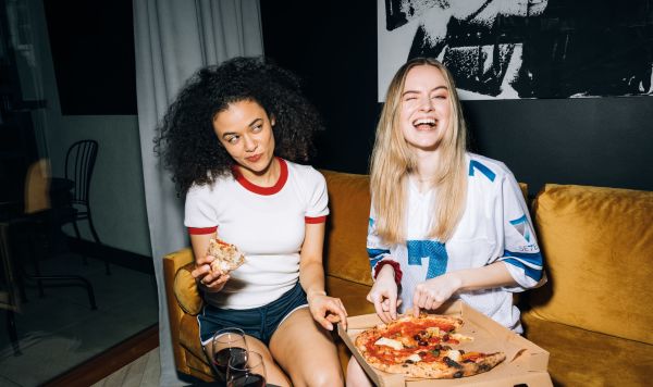 Девушки едят пиццу