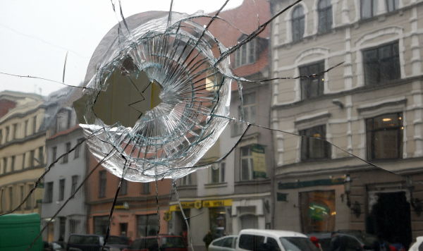 Разбитая витрина после массовой акции протеста в Риге