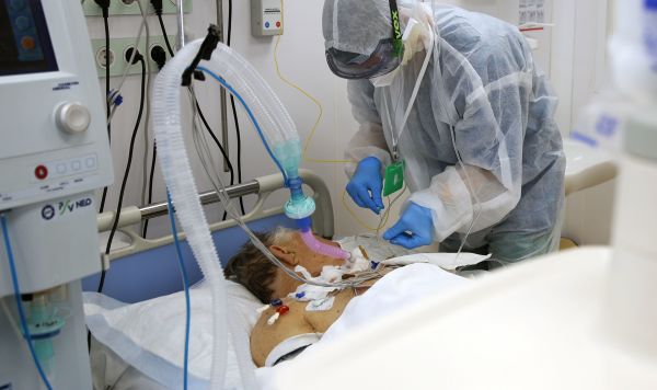 Медицинский работник у пациента в реанимационном отделении для больных Covid-19