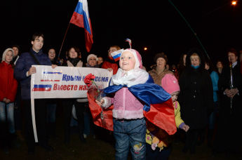 Жители Симферополя смотрят трансляцию праздничного концерта в честь подписания договора о принятии Крыма в состав Российской Федерации на центральной площади города, 18 марта 2014 года