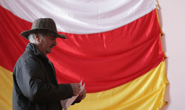 Мужчина на фоне флага Южной Осетии