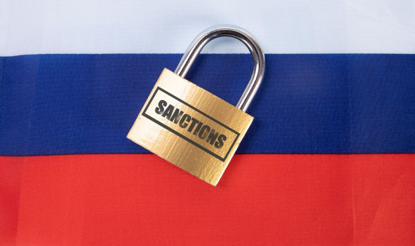 Замок с надписью "Санкции" на фоне флага России