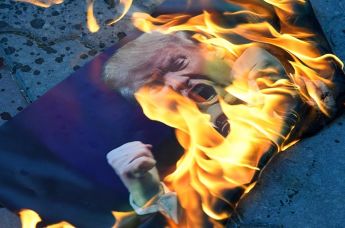 Участники акции против ракетных ударов по Сирии в Симферополе сжигают портрет президента США Дональда Трампа