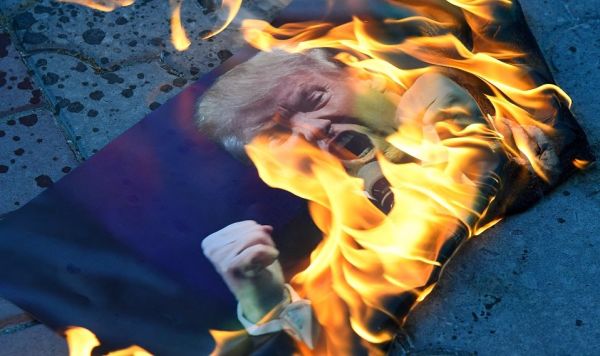 Участники акции против ракетных ударов по Сирии в Симферополе сжигают портрет президента США Дональда Трампа