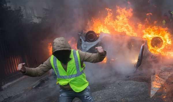 Автомобиль, горящий во время протестной акции движения автомобилистов "желтые жилеты", выступавшего с требованием снижения налогов на топливо, в районе Триумфальной арки в Париже.