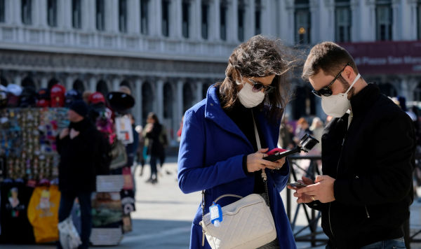 Туристы в защитных масках на площади Сан-Марко в Венеции, Италия, 27 февраля 2020 года