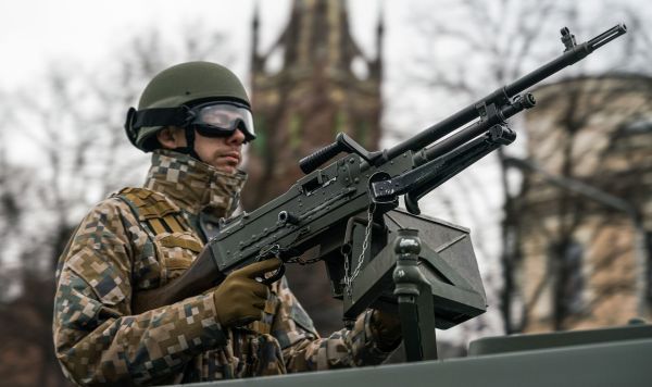 Латвийский военный за пулеметной установкой на параде в Риге в День независимости Латвии
