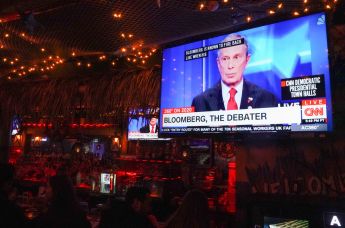 Посетители бара Wicked Willy's в Нью-Йорке смотрят трансляцию теледебатов кандидатов в президенты США от Демократической партии, проходящих в Лас-Вегасе