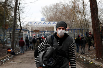 Мигрант в маске на турецком пограничном пункте Пазаркуле, Греция, 5 марта 2020