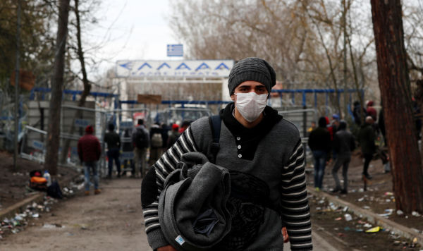 Мигрант в маске на турецком пограничном пункте Пазаркуле, Греция, 5 марта 2020