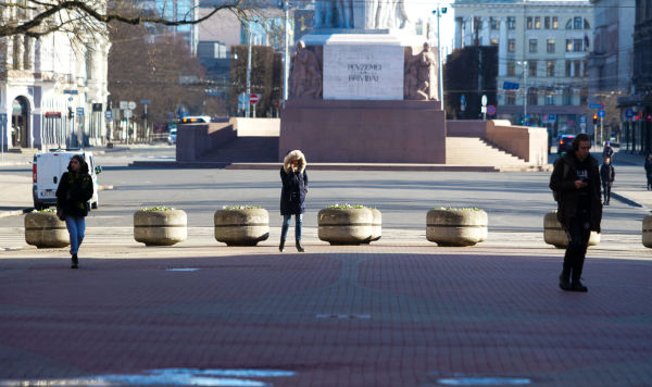 Люди соблюдают социальную дистанцию, передвигаясь в центре Риги