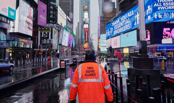 Мужчина из объединения Times Square Alliance на пустой Таймс-сквер в Нью-Йорке