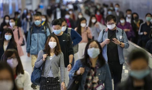 Жители пригородной зоны в медицинских масках на переходе одной из станций метро в Гонконге