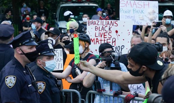 Полицейские стоят в оцеплении во время протеста, вызванного смертью афроамериканца Джорджа Флойда, на одной из улиц Нью-Йорка