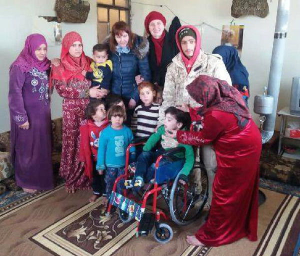 Представители "Евразийского народного союза" передают многодетной сирийской семье детскую инвалидную коляску