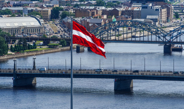 Латвийский флаг на фоне Риги