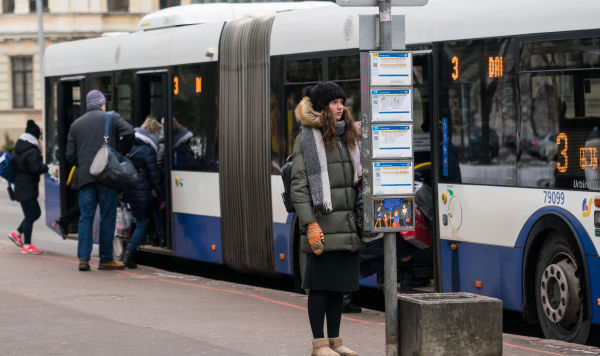 Девушка на остановке городского транспорта в Риге