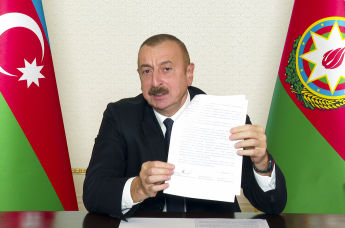 Президент Азербайджана Ильхам Алиев держит в руках соглашение по Нагорному Карабаху, 10 ноября 2020