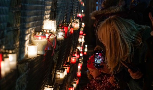 Латвийцы несут памятные свечи к стене Рижского замка в День Лачплесиса, 11 ноября 2020