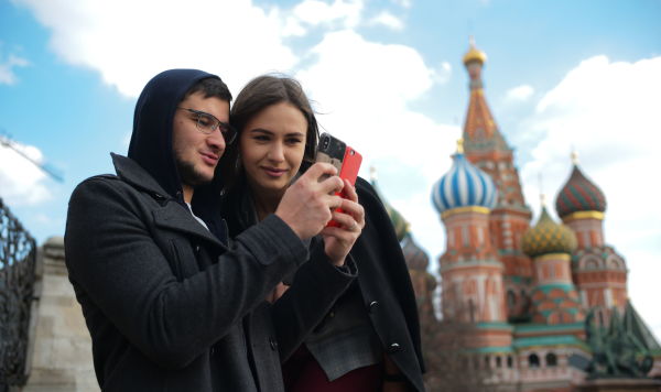 Молодые люди фотографируются на Красной площади в Москве