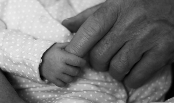 Рука младенца и рука пожилого человека