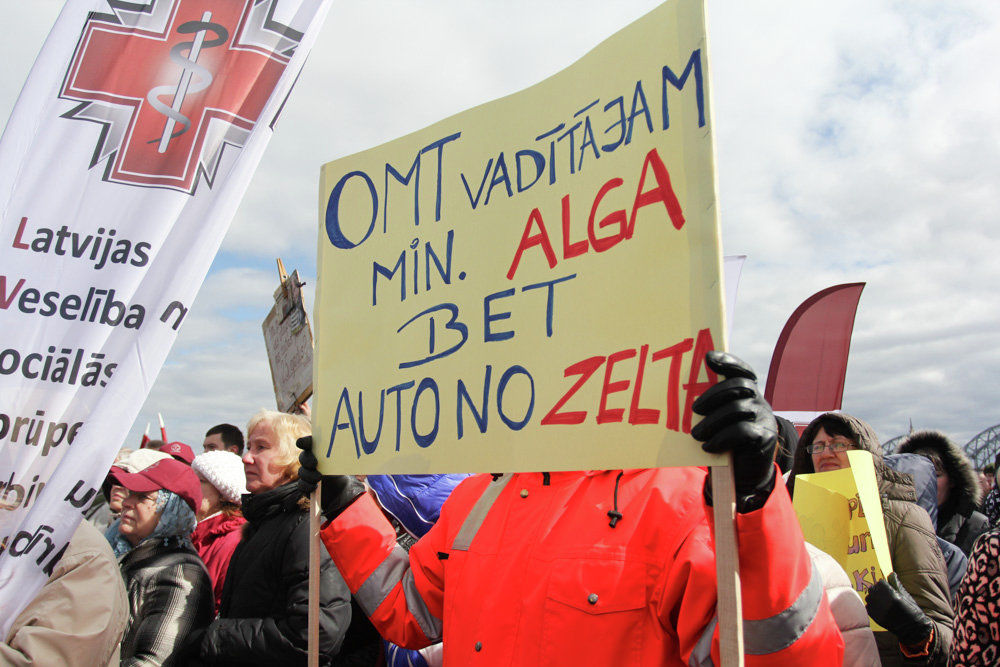 Плакат в руках медика гласит: «У шофера скорой помощи - минимальная зарплата, а машина - из золота».