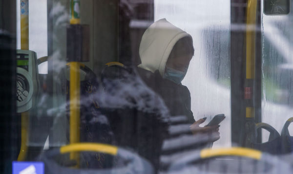 Женщина в маске в  общественном транспорте в Риге