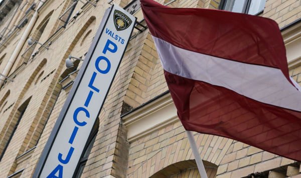 Флаг Латвии у вывески отдела полиции в Риге 