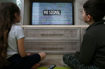 Дети у телевизора с изображением эфирного шума