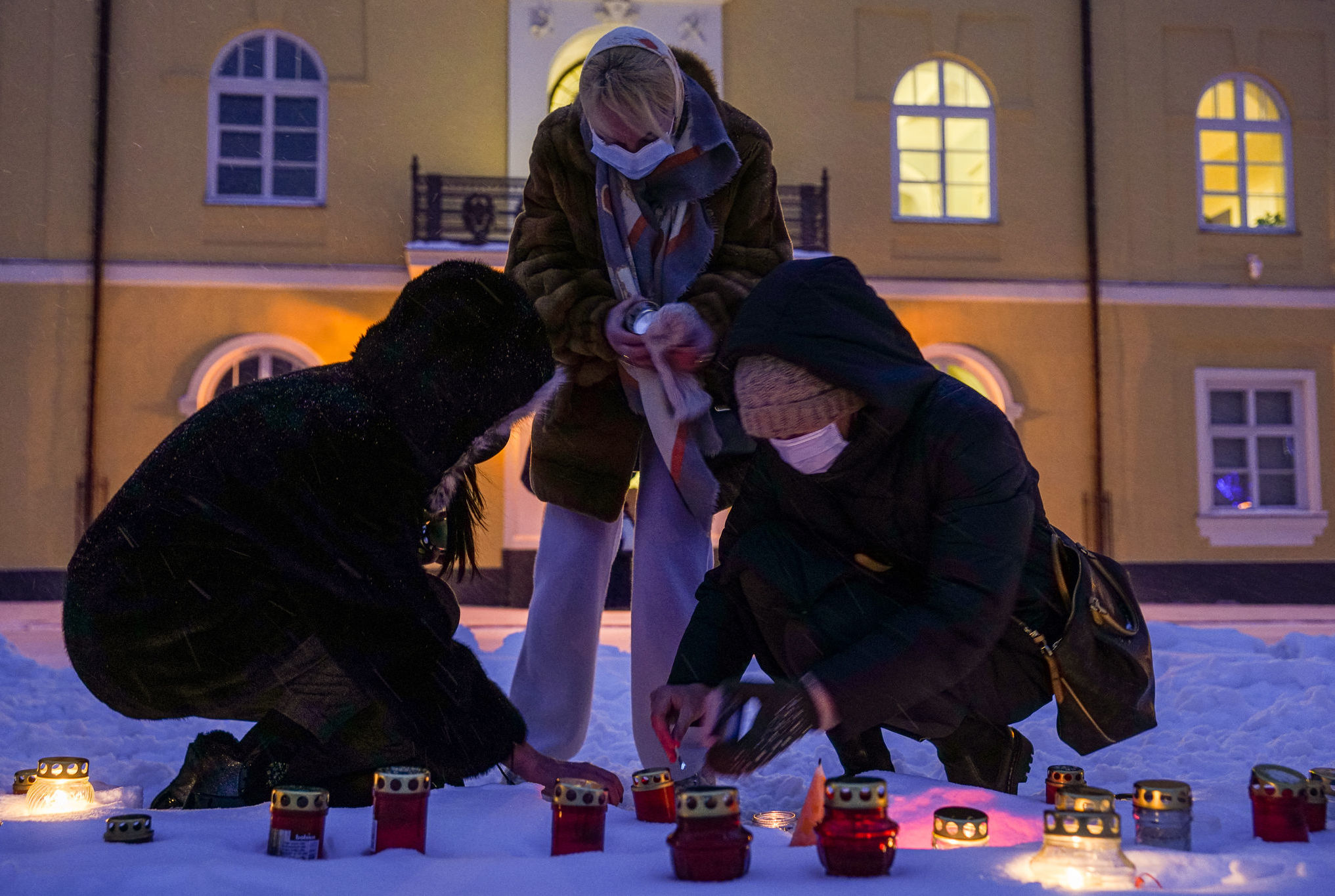 Рижане зажигают свечи у Рижского замка, обращая внимание президента Латвии на трудное положение населения страны из-за введенных ограничений в связи с пандемией COVID-19, 10 февраля 2021