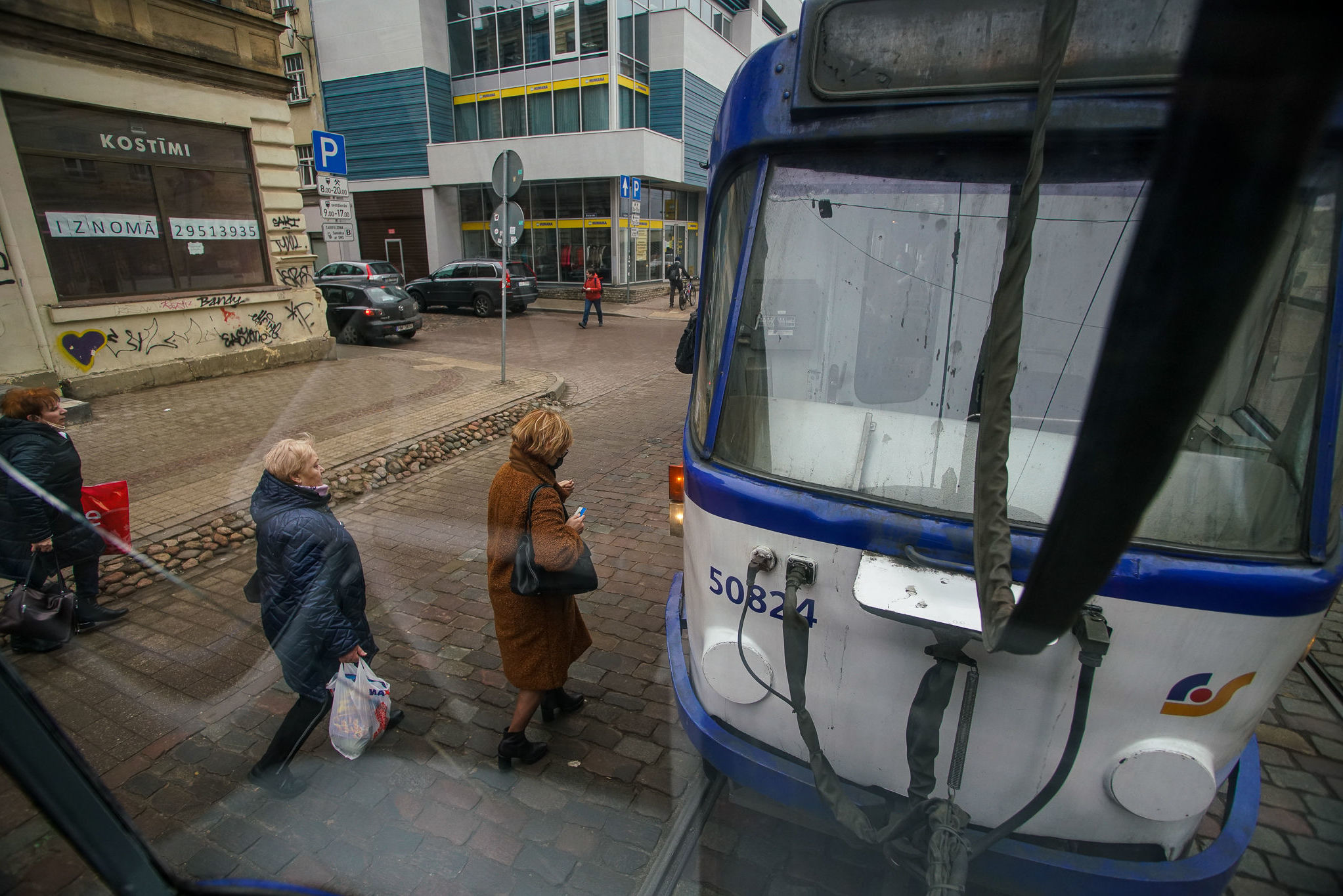 Пассажиры на трамвайной остановке в Риге