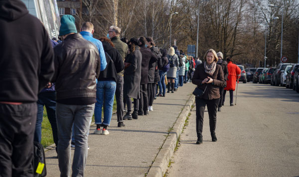Люди стоят в очереди на прививку от COVID-19 в Риге