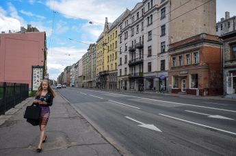 Девушка идет по улице Бривибас в центре Риги в Латвии