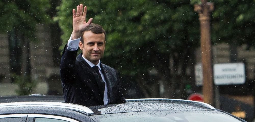 Президент Франции Эммануэль Макрон в автомобиле президентского кортежа приветствует граждан в день своей инаугурации в Париже.