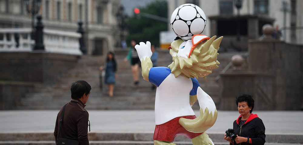 Туристы у фигуры официального талисмана чемпионата мира по футболу 2018 волка Забиваки, установленной к чемпионату мира по футболу 2018, на Манежной площади в Москве.