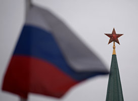Шпиль одной из башен Московского Кремля и государственный флаг России на Красной площади