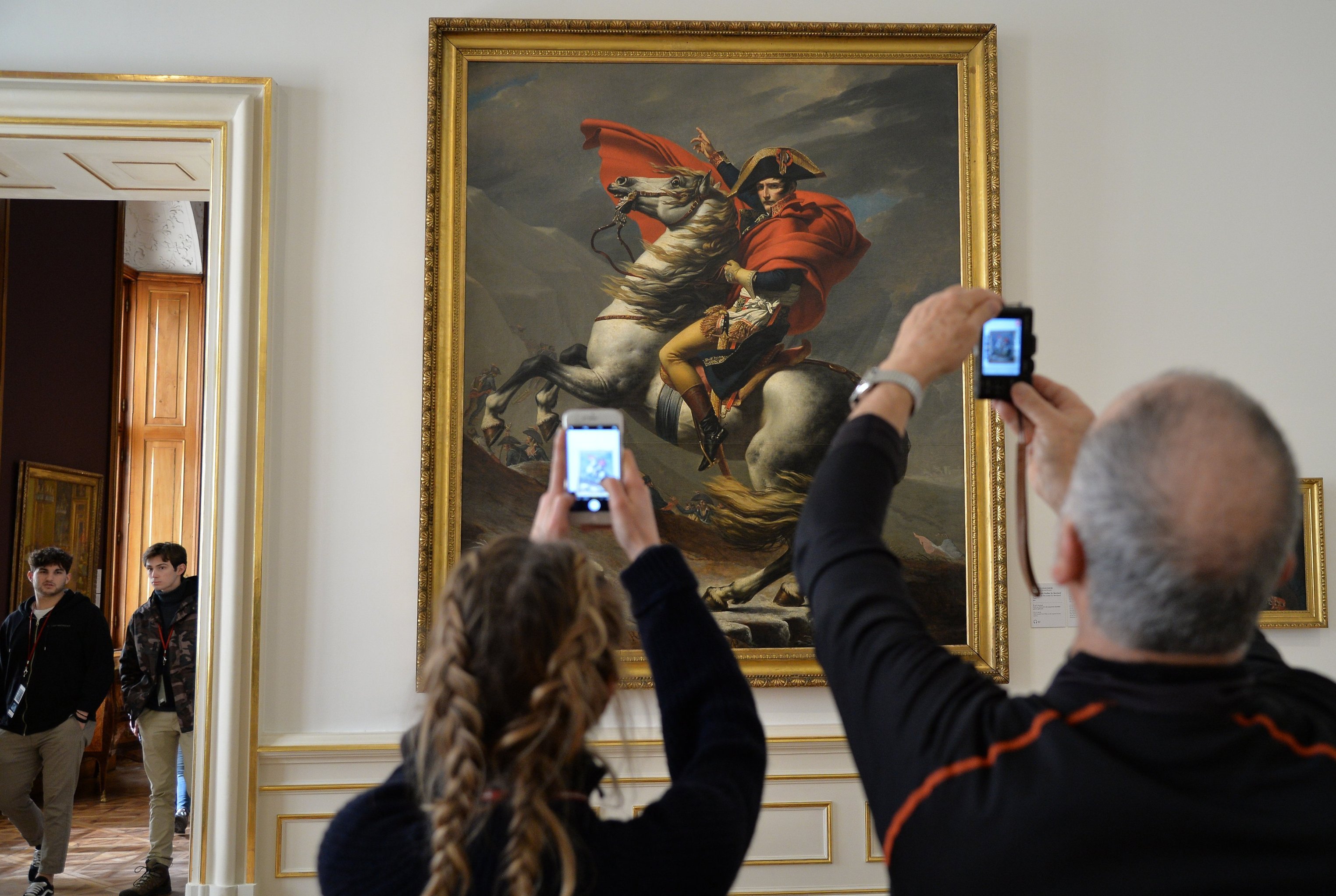 Посетители у картины Жака-Луи Давида "Наполеон на перевале Сен-Бернар" в галерее Бельведер - художественном музее в венском дворце Бельведер