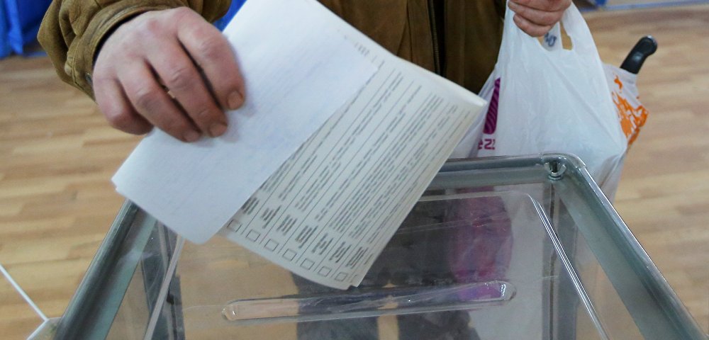 Мужчина бросает бюллетень в урну во время голосования на выборах президента Украины на одном из избирательных участков Киева, 31 марта 2019