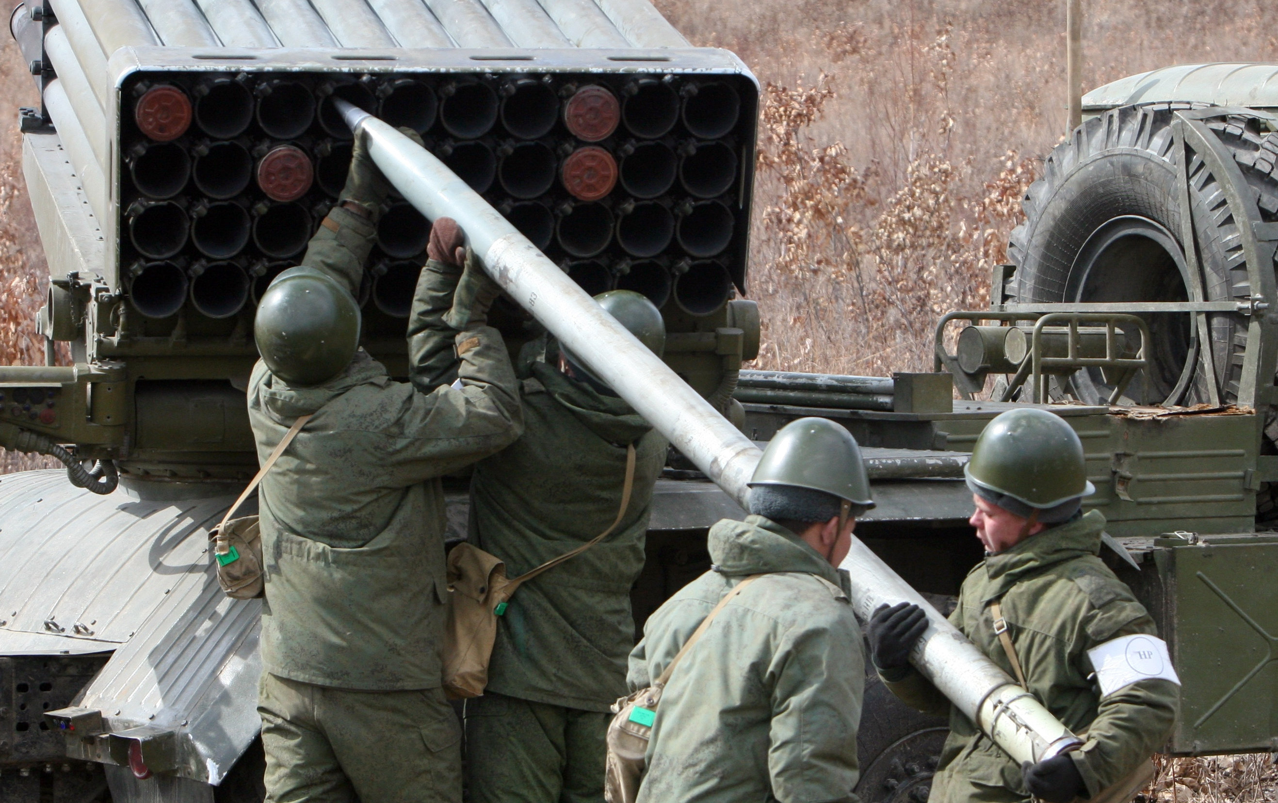 Военнослужащие перезаряжают реактивную систему залпового огня "Град"