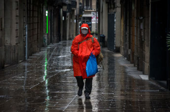 Мужчина в защитной маске идет по улице в центре Барселоны