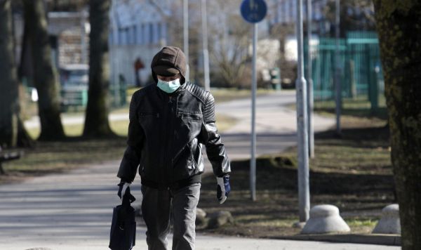 Мужчина в защитной маске на улице Таллина